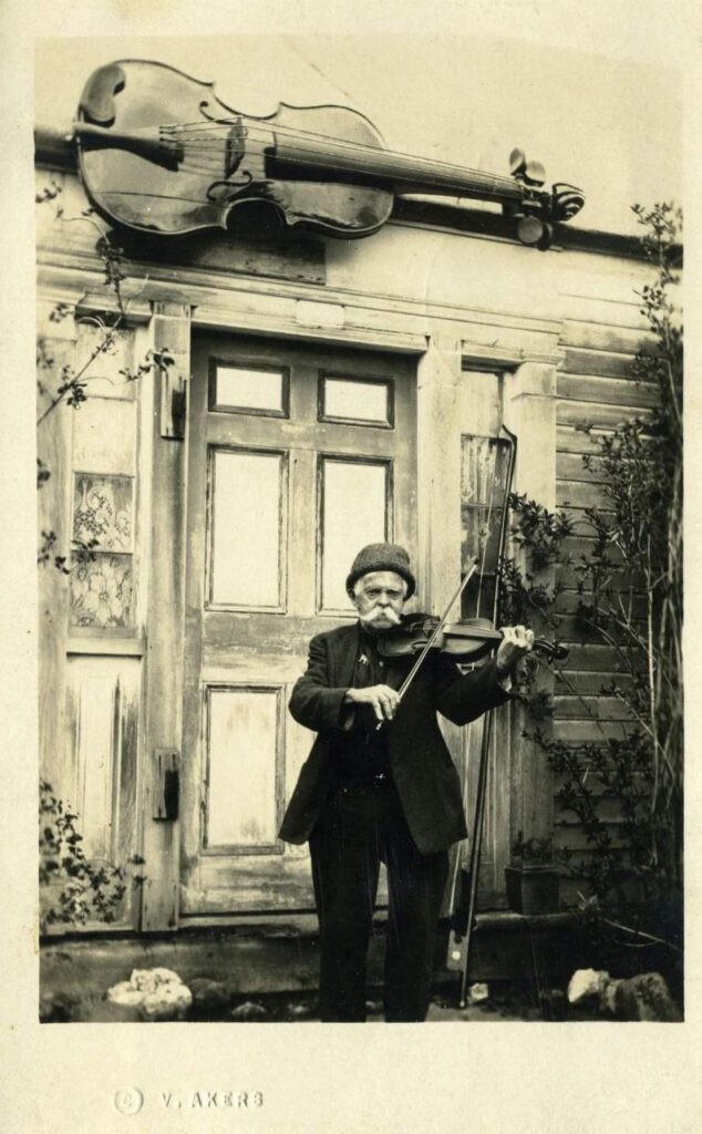 Alanson Mellen "Mellie" Dunham, Jr. (ca. 1927) posing with one of his fiddles.