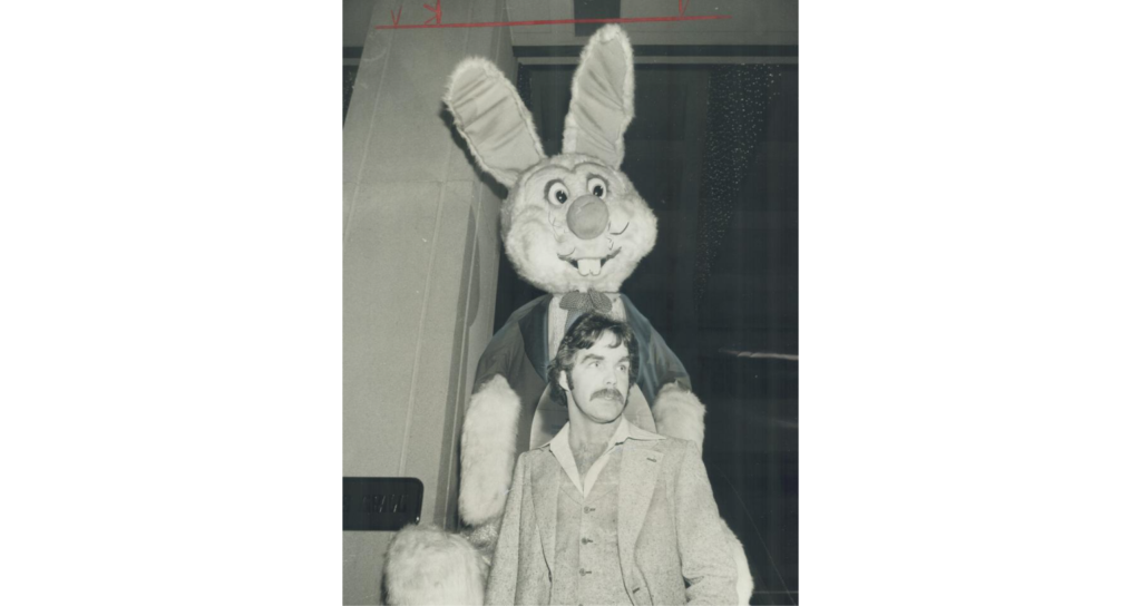 Toronto Star photo of hockey star, Derek Sanderson, while large stuffed rabbit looms over him.